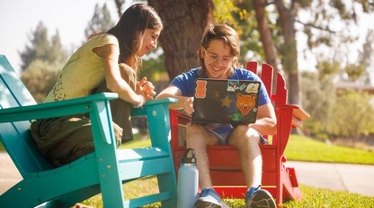 Two students on the mounds w/ laptop