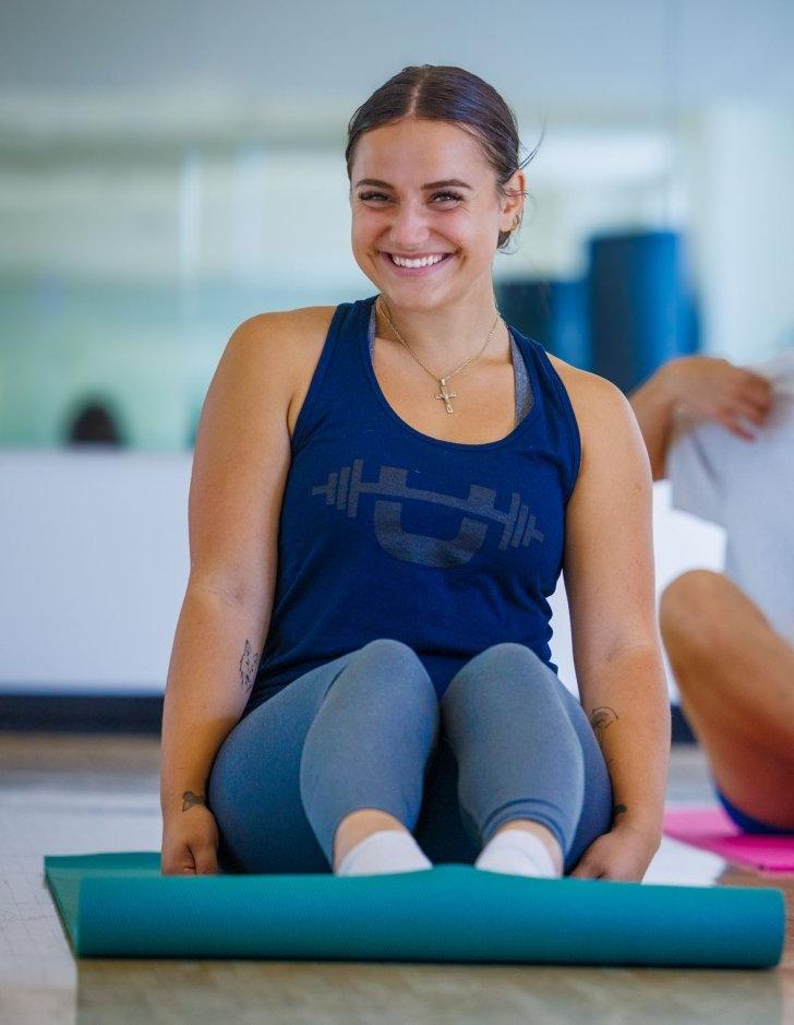 Student smiles while praticing yoga